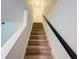 Carpeted staircase with a dark handrail leads to the upper level, providing a comfortable transition at 3150 Stratford Green Pl, Avondale Estates, GA 30002