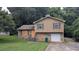 Two-story home with stone base and boarded-up windows, set amongst trees at 3778 Glen Mora Dr, Decatur, GA 30032