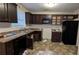 A kitchen with dark wood cabinets and black appliances at 3778 Glen Mora Dr, Decatur, GA 30032
