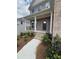 Charming front entrance with brick steps and white pillars supporting the covered front porch at 4266 Mulberry Pass Ct, Hoschton, GA 30548