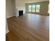 Spacious living room showcasing hardwood flooring, a fireplace, and large windows for natural light at 4266 Mulberry Pass Ct, Hoschton, GA 30548
