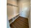 Mudroom with convenient built in storage and bench with hooks on the wall for easy organization at 4266 Mulberry Pass Ct, Hoschton, GA 30548