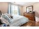 Cozy bedroom with hardwood floors, curtains, plush bed, and dresser with mirror at 4903 Wilkie Nw Way, Acworth, GA 30102