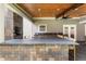 Entertainers outdoor kitchen with stone countertop, custom cabinets and adjacent living space at 4903 Wilkie Nw Way, Acworth, GA 30102
