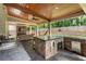Outdoor kitchen with stone facade, sink, built-in cabinets, counter seating, and outdoor living area at 4903 Wilkie Nw Way, Acworth, GA 30102