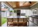 Outdoor kitchen with barstool seating, cabinets, stone facade, and wood ceiling with fan at 4903 Wilkie Nw Way, Acworth, GA 30102