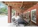 Covered patio with brickwork, exposed beams, and an outdoor dining area next to the pool at 750 Old Loganville Road Southwest, Loganville, GA 30052