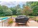 Deck with a grill overlooking a backyard pool and lush green space at 750 Old Loganville Road Southwest, Loganville, GA 30052
