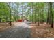 Scenic driveway leading to a red barn-style garage surrounded by lush greenery and mature trees at 750 Old Loganville Road Southwest, Loganville, GA 30052