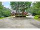 Stately brick home with a circular driveway, mature landscaping, and attached garage nestled on a wooded lot at 750 Old Loganville Road Southwest, Loganville, GA 30052