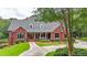 Charming red brick home with a manicured lawn, covered porch with columns, and mature trees in a tranquil setting at 750 Old Loganville Road Southwest, Loganville, GA 30052