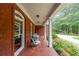 Inviting front porch with brick flooring, white columns, a seating area, and views of a landscaped yard at 750 Old Loganville Road Southwest, Loganville, GA 30052