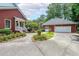 Detached garage with a brick exterior, lush landscaping, and a charming entryway at 750 Old Loganville Road Southwest, Loganville, GA 30052