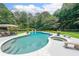 Inviting backyard pool and spa surrounded by lush landscaping and stone benches for ultimate relaxation at 750 Old Loganville Road Southwest, Loganville, GA 30052