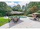 Lush backyard oasis with a swimming pool, hot tub, shaded dining, and landscaped yard at 750 Old Loganville Road Southwest, Loganville, GA 30052