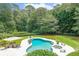 Aerial view of a backyard with a pool, spa, and manicured greenery at 750 Old Loganville Road Southwest, Loganville, GA 30052