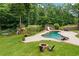 Aerial view showcasing the swimming pool with slide, fire pit, and custom-built playground nestled in a wooded lot at 217 Heritage Town Pkwy, Canton, GA 30115