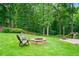 Picturesque backyard featuring a fire pit, seating area, and a wooded backdrop at 217 Heritage Town Pkwy, Canton, GA 30115