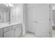 Bright bathroom featuring a large mirror, white cabinetry, and neutral tile floors at 217 Heritage Town Pkwy, Canton, GA 30115