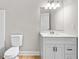 Bathroom featuring white vanity, marble countertop, modern mirror, and hardwood flooring at 217 Heritage Town Pkwy, Canton, GA 30115