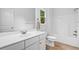 Bright bathroom featuring a single sink vanity, toilet, and shower-tub with white fixtures at 217 Heritage Town Pkwy, Canton, GA 30115