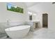 Bathroom features a standalone tub, double sink vanity, large mirror, and a window with natural lighting at 217 Heritage Town Pkwy, Canton, GA 30115