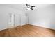 A bedroom featuring light hardwood floors, a ceiling fan, and doorways to an ensuite bathroom and closet at 217 Heritage Town Pkwy, Canton, GA 30115