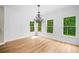 Dining room with hardwood floors, a decorative chandelier, and multiple windows with views of the trees at 217 Heritage Town Pkwy, Canton, GA 30115
