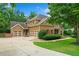View of a three-car garage and driveway with mature landscaping around this home at 217 Heritage Town Pkwy, Canton, GA 30115