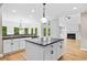 Modern kitchen with granite counters, island, and adjacent living room with fireplace at 217 Heritage Town Pkwy, Canton, GA 30115
