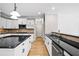 Modern kitchen with granite countertops, stainless steel appliances, white cabinets, and hardwood floors at 217 Heritage Town Pkwy, Canton, GA 30115