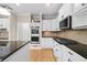 Bright kitchen boasts stainless steel appliances, custom cabinets, and hardwood flooring at 217 Heritage Town Pkwy, Canton, GA 30115