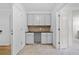Office area with gray cabinets, dark counter, beige carpet, and doorway at 217 Heritage Town Pkwy, Canton, GA 30115
