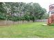 Large, grassy backyard enclosed by a wooden fence and bordered by mature trees, providing privacy at 3302 Bellingham Way, Lithia Springs, GA 30122