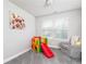 Bright room with a colorful slide, cozy grey armchair, and window at 3302 Bellingham Way, Lithia Springs, GA 30122