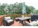 Outdoor deck featuring outdoor seating, table with umbrella, and lush greenery at 3302 Bellingham Way, Lithia Springs, GA 30122