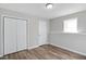 This bright bedroom boasts wood-look floors, natural light, and double closets for ample storage at 341 Windermere Dr., Loganville, GA 30052