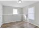 This bright bedroom boasts wood-look floors and two windows with natural light at 341 Windermere Dr., Loganville, GA 30052