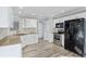 Kitchen with stainless steel appliances, stone countertops, white cabinetry, and hardwood flooring at 341 Windermere Dr., Loganville, GA 30052
