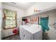 Bright laundry room with washer and dryer, natural light, and creative decor at 133 Sw Patterson Rd, Lawrenceville, GA 30044