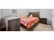 Bedroom with neutral carpet, bed, orange duvet and wooden furniture at 1991 Flat Shoals Rd, Riverdale, GA 30296