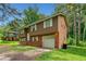 Two-story home with brown siding, brick accents, and an attached one-car garage at 1991 Flat Shoals Rd, Riverdale, GA 30296