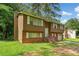 Charming two-story home with brown siding, brick accents, white shutters, and a well-maintained front yard at 1991 Flat Shoals Rd, Riverdale, GA 30296