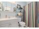 Bright, fresh bathroom with glass shelving, colorful shower curtain and vanity at 3698 Lakeview Drive, Tucker, GA 30084