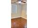 An empty bedroom has wood floors, a ceiling fan, and a window with blinds at 6197 Union Grove Rd, Lithia Springs, GA 30122