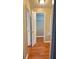 A bright hallway has wood flooring and a view into a walk-in closet with shelves at 6197 Union Grove Rd, Lithia Springs, GA 30122
