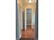 Hallway view with neutral walls and vinyl floors leading to a room with open closet at 6197 Union Grove Rd, Lithia Springs, GA 30122