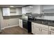 Modern kitchen with white cabinets, stainless steel appliances, and vinyl flooring at 6197 Union Grove Rd, Lithia Springs, GA 30122