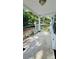 A front porch with concrete flooring, white rails, and views of mature trees at 6197 Union Grove Rd, Lithia Springs, GA 30122
