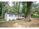 Charming home featuring a welcoming front porch with an orange door surrounded by beautiful trees at 2437 Clarissa Nw Dr, Atlanta, GA 30318